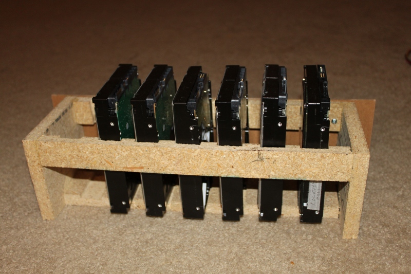A simple, slotted wooden cage for 7 hard drives